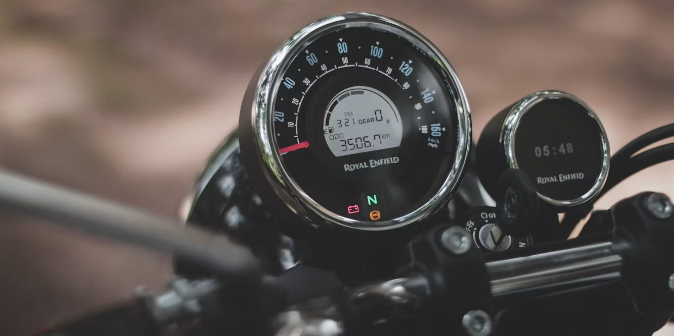 A close view of a motorcycle speedometer and a secondary instrument dial mounted above the fork