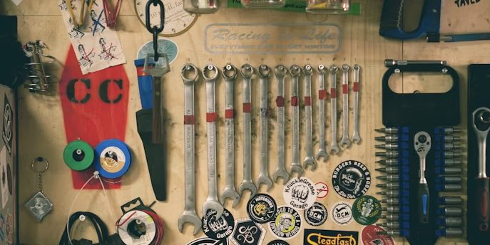 A workshop tool wall with spanners, keys and hand tools hung in rows against plywood